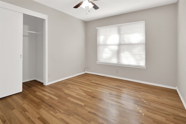 unfurnished bedroom featuring wood-type flooring, a closet, and ceiling fan