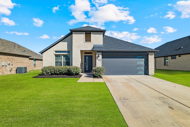 view of front of home featuring a front yard, a garage, and central AC unit