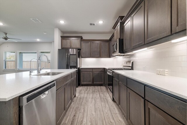 kitchen with sink, ceiling fan, appliances with stainless steel finishes, light hardwood / wood-style floors, and dark brown cabinetry