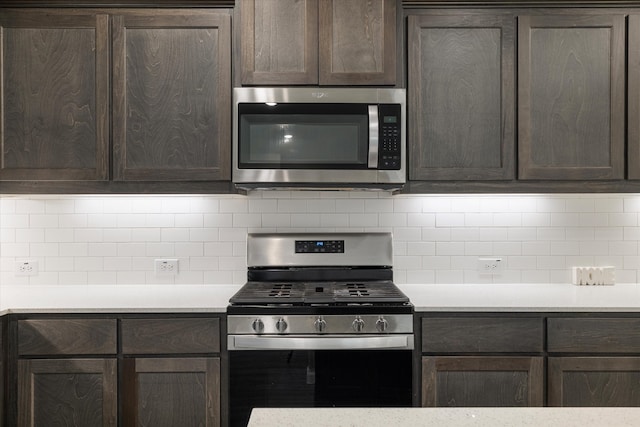 kitchen with dark brown cabinetry, decorative backsplash, and appliances with stainless steel finishes