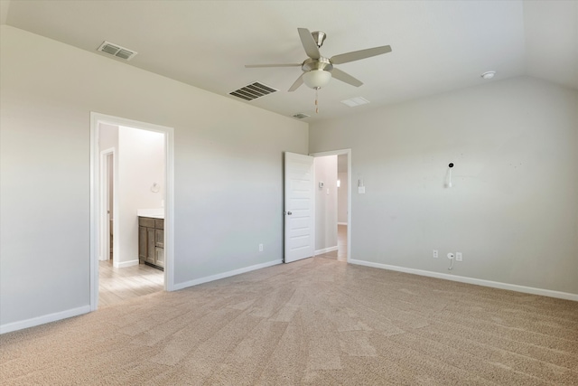 unfurnished bedroom with ceiling fan, ensuite bathroom, vaulted ceiling, and light carpet