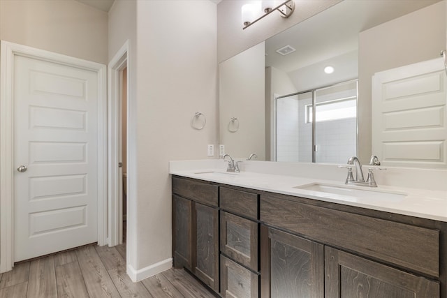 bathroom featuring hardwood / wood-style floors, vanity, and a shower with shower door