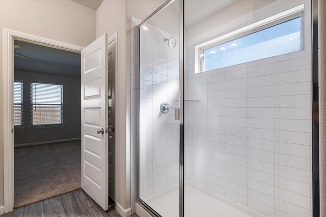 bathroom with hardwood / wood-style flooring and a shower with shower door