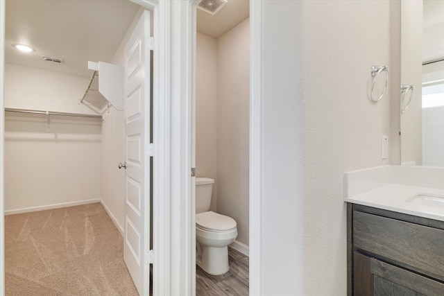 bathroom featuring hardwood / wood-style floors, vanity, and toilet