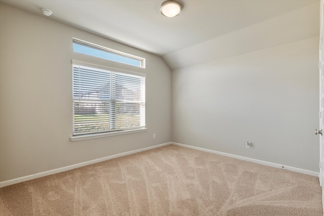 empty room featuring light carpet and lofted ceiling