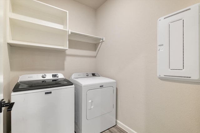 laundry area featuring washer and clothes dryer and light hardwood / wood-style floors