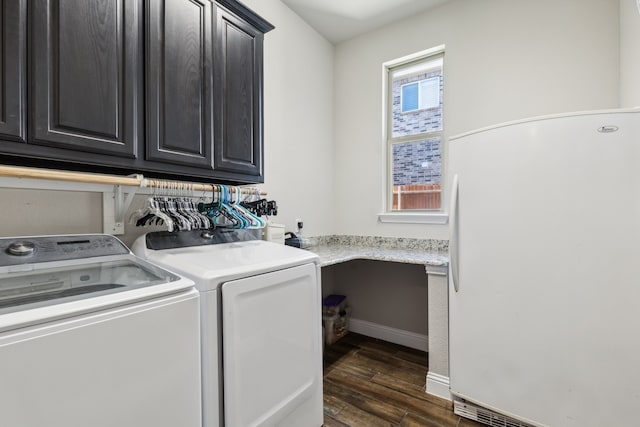 laundry room featuring cabinets, washer and clothes dryer, and dark wood-type flooring