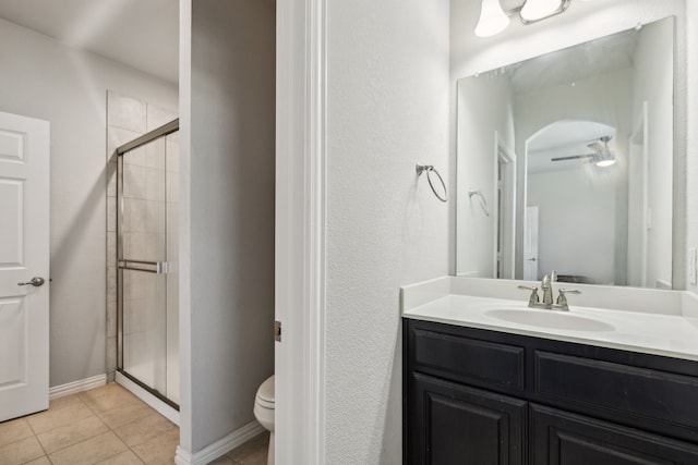 bathroom featuring tile patterned floors, ceiling fan, toilet, and a shower with door