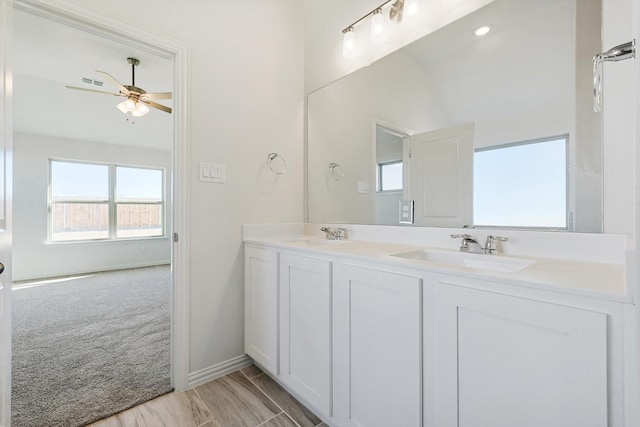 bathroom featuring ceiling fan, double vanity, a sink, and visible vents