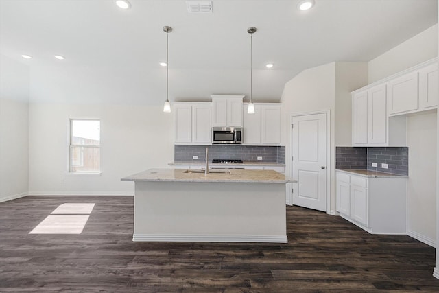 kitchen featuring white cabinetry, a kitchen island with sink, and stainless steel microwave