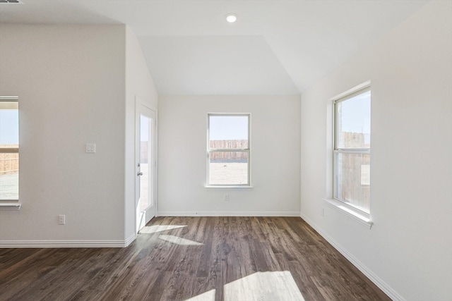 interior space with lofted ceiling, baseboards, dark wood finished floors, and a healthy amount of sunlight