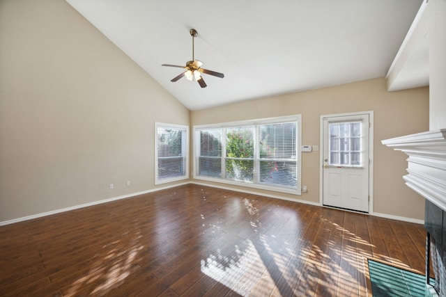 unfurnished living room with a wealth of natural light, dark hardwood / wood-style flooring, and high vaulted ceiling