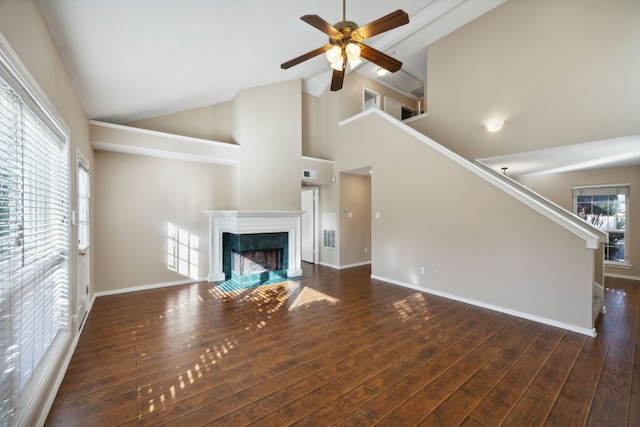 unfurnished living room with high vaulted ceiling, ceiling fan, and dark wood-type flooring