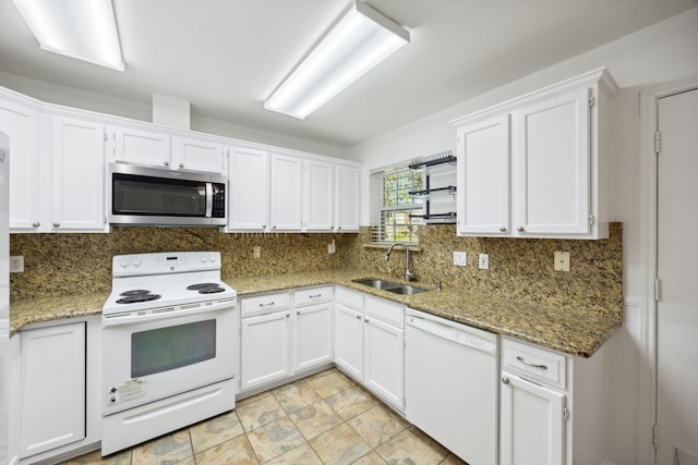 kitchen featuring white cabinetry, sink, light stone countertops, white appliances, and decorative backsplash