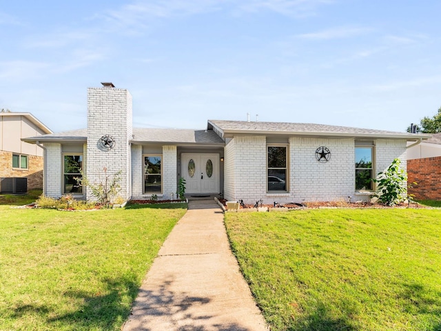 ranch-style house featuring a front lawn and central air condition unit