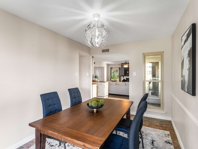 dining area featuring dark hardwood / wood-style floors and ceiling fan with notable chandelier