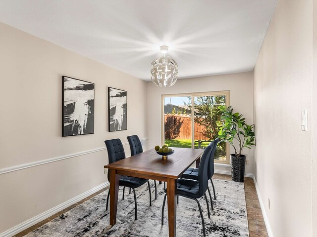 dining space with hardwood / wood-style floors and a notable chandelier