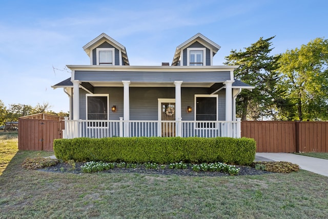 view of front of property featuring covered porch and a front yard