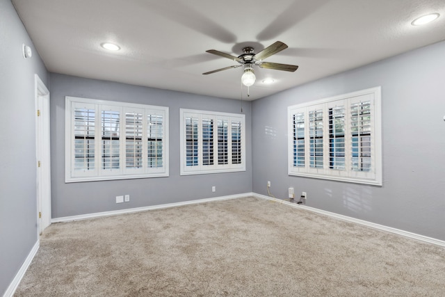 carpeted spare room featuring ceiling fan