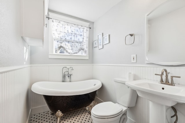 bathroom featuring a bathing tub, toilet, and lofted ceiling