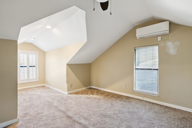 additional living space featuring a wall mounted air conditioner, light carpet, vaulted ceiling, and ceiling fan