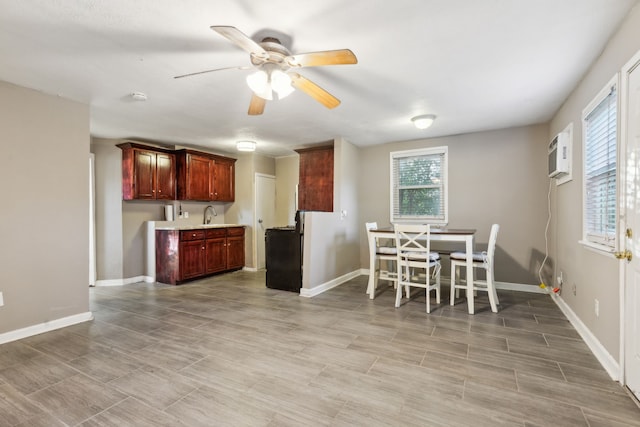 dining area featuring an AC wall unit, ceiling fan, and sink