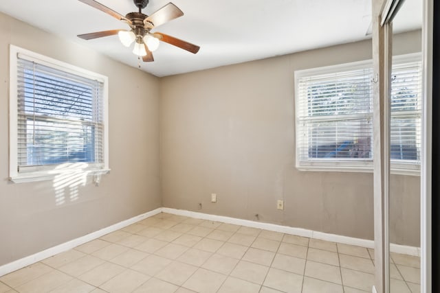 spare room with ceiling fan and light tile patterned flooring