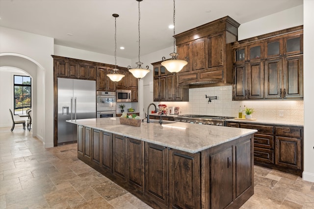 kitchen featuring sink, dark brown cabinets, and built in appliances