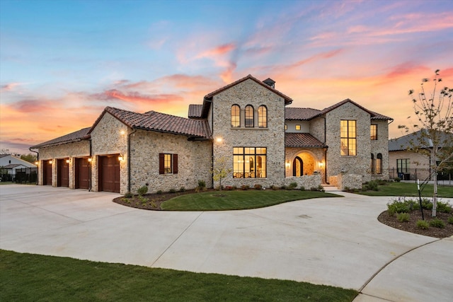 view of front of property with a garage and a lawn