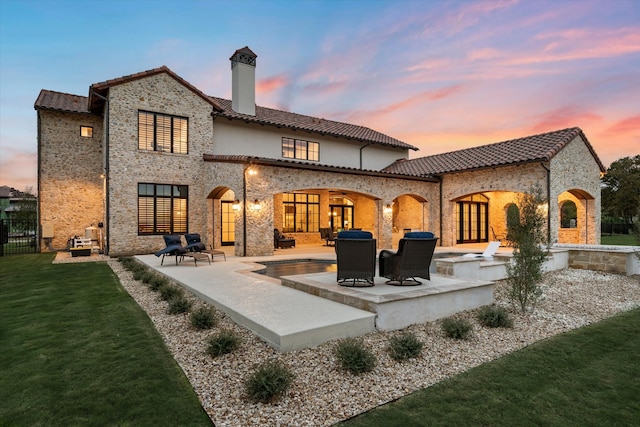 back of property with a fenced in pool, a patio, and a yard