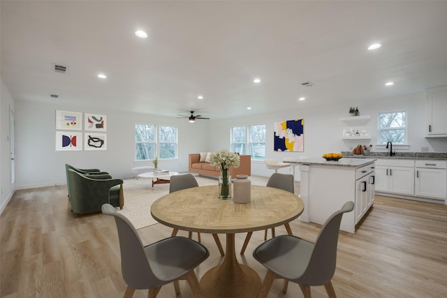 dining area with ceiling fan and light wood-type flooring