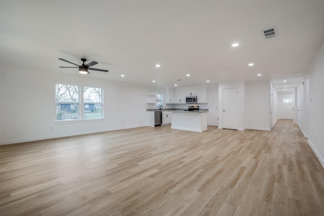 unfurnished living room featuring light wood-type flooring and ceiling fan