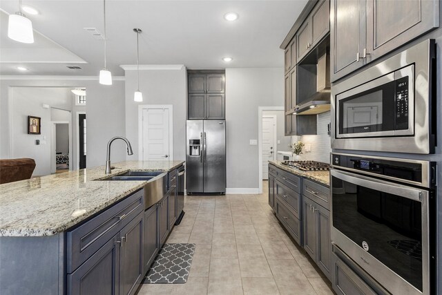 kitchen with sink, ventilation hood, pendant lighting, a spacious island, and appliances with stainless steel finishes