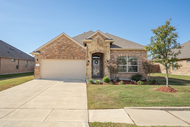 view of front of property featuring a front yard and a garage