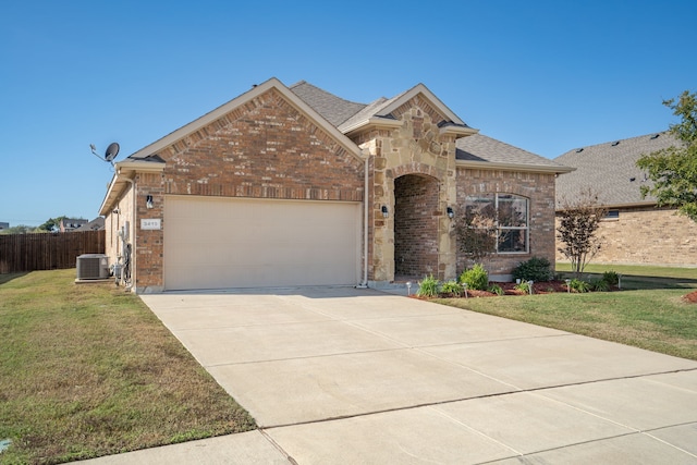 view of front facade with a front yard, central AC, and a garage