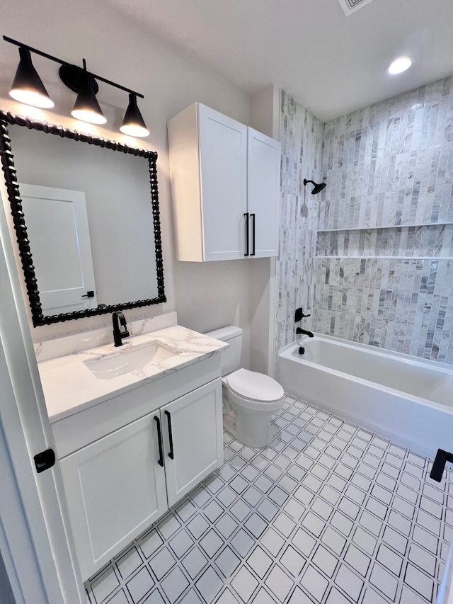 full bathroom with toilet, vanity, and tiled shower / bath