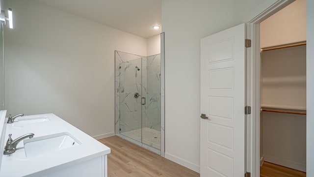 bathroom with vanity, wood-type flooring, and a shower with shower door