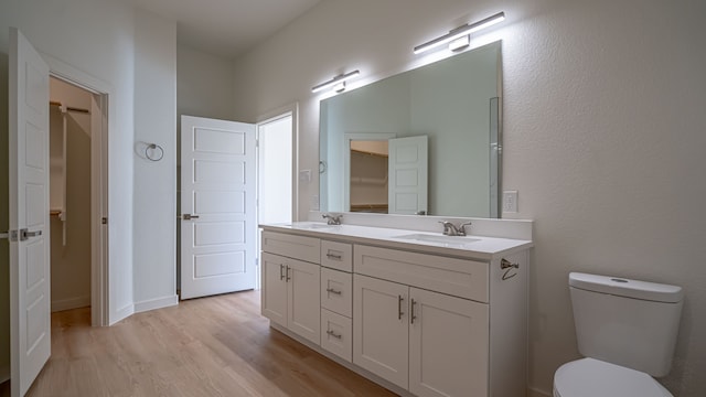 bathroom featuring toilet, vanity, and hardwood / wood-style flooring