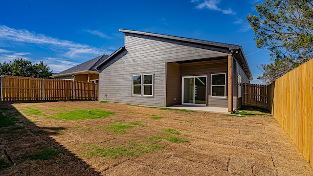 back of house featuring a lawn and a patio