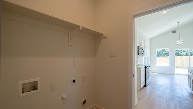 clothes washing area featuring hookup for an electric dryer, hookup for a washing machine, light hardwood / wood-style flooring, and hookup for a gas dryer