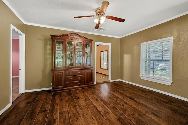 empty room with a textured ceiling, crown molding, ceiling fan, and dark hardwood / wood-style floors