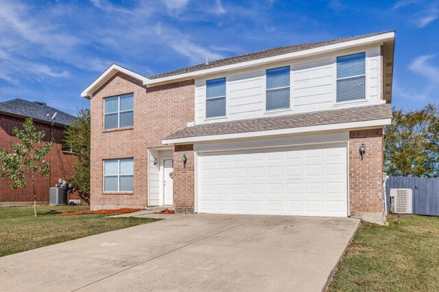 view of front of house featuring a garage, central AC unit, and a front lawn