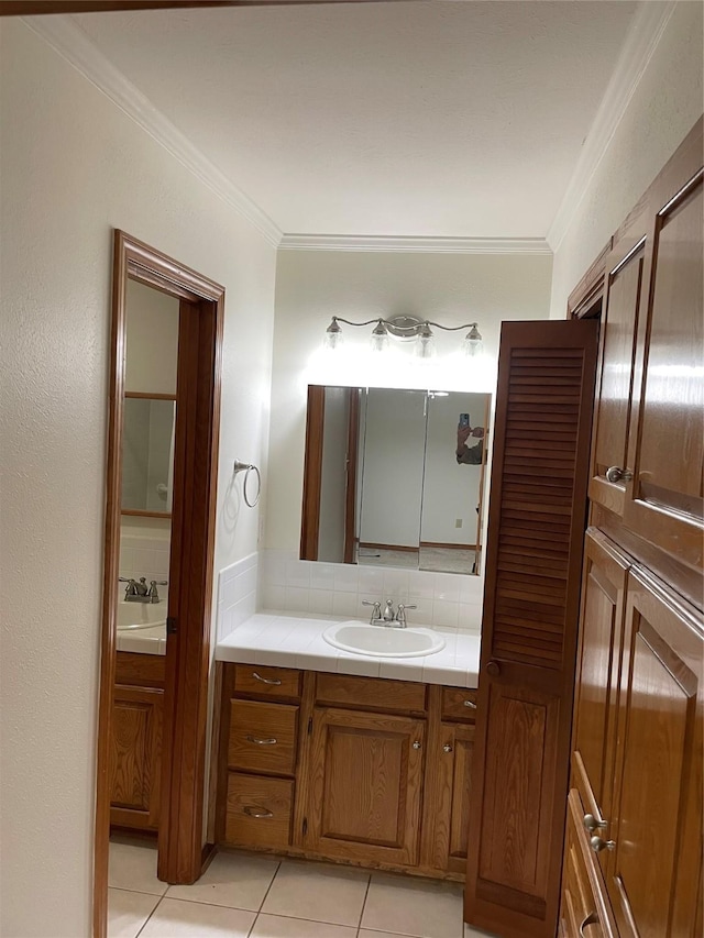 bathroom featuring tile patterned flooring, decorative backsplash, crown molding, and vanity