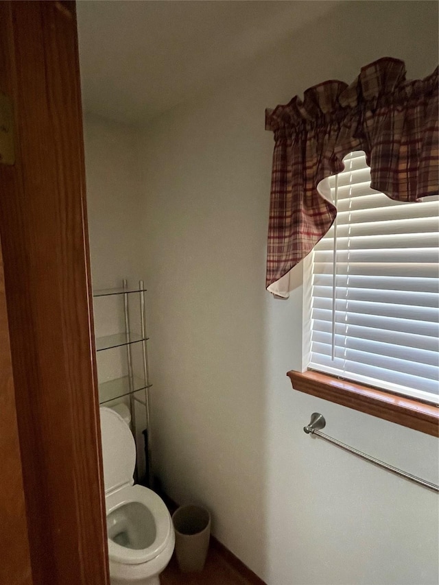 bathroom featuring toilet and baseboards