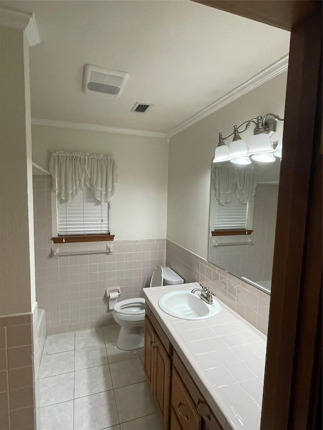 bathroom with visible vents, ornamental molding, tile patterned flooring, vanity, and tile walls