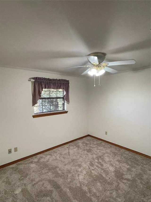 carpeted empty room with ceiling fan and baseboards