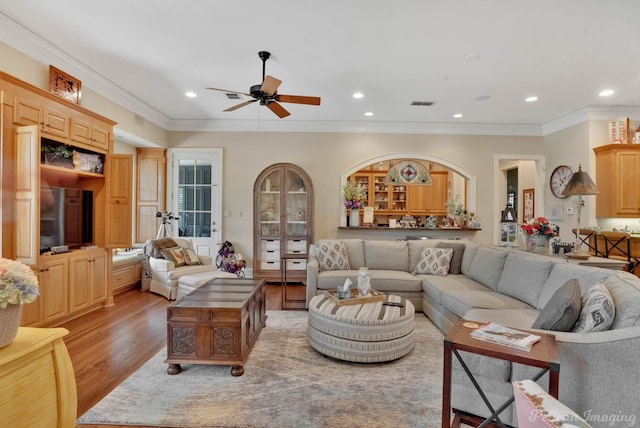 living room featuring ceiling fan, light hardwood / wood-style floors, and ornamental molding