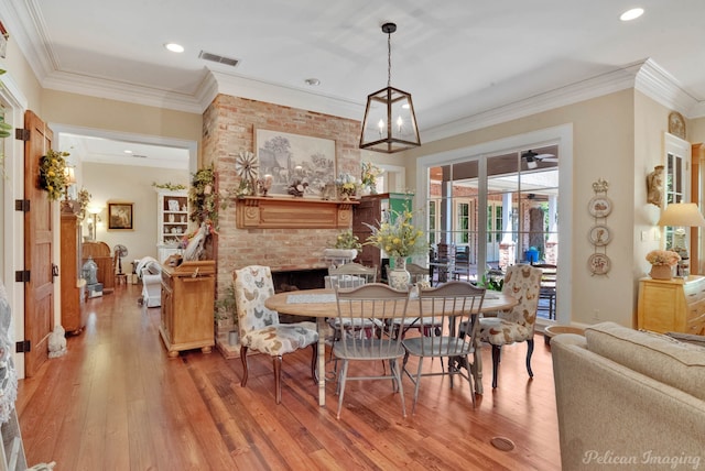 dining space with crown molding, a notable chandelier, and hardwood / wood-style flooring