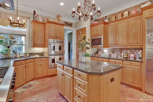 kitchen with stainless steel appliances, a kitchen island, hanging light fixtures, and a notable chandelier