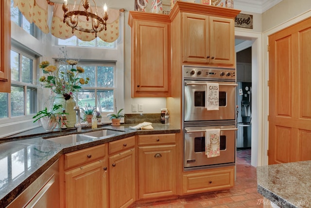 kitchen featuring ornamental molding, double oven, sink, decorative light fixtures, and a notable chandelier